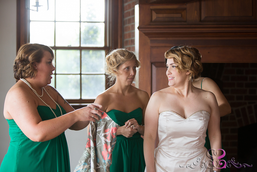 08 - bride smiles at bridesmaids while getting ready grand rapids michigan wedding photographer