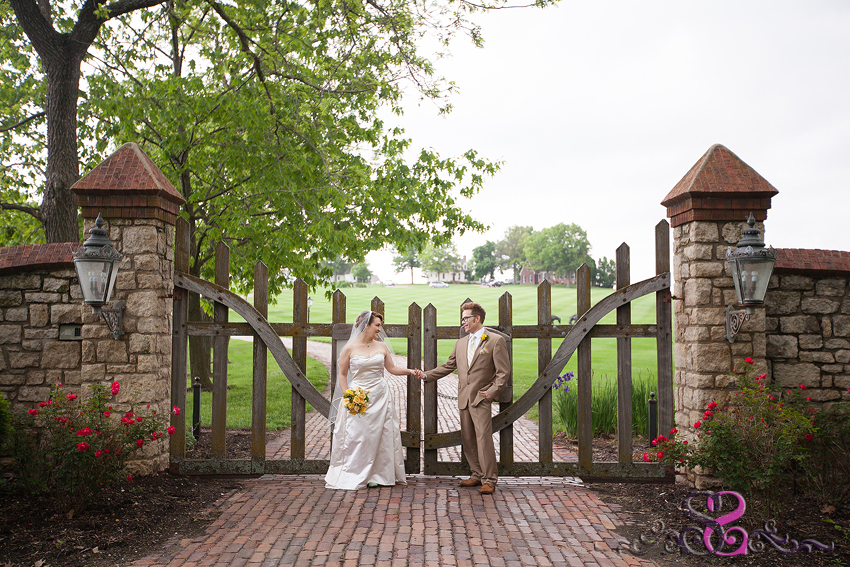 17 - bride and groom hold hands in front of wooden gate lawrence wedding photographer