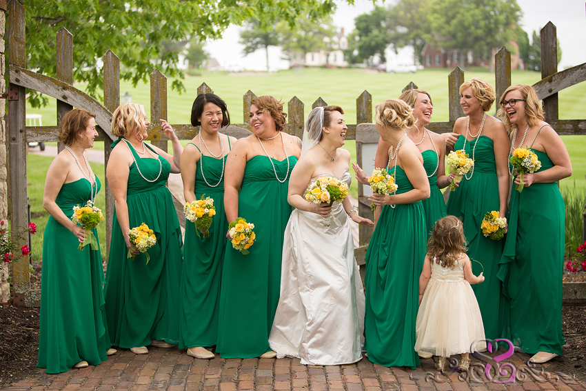 23 - bridesmaids laugh in front of wooden gate kansas city wedding photographer