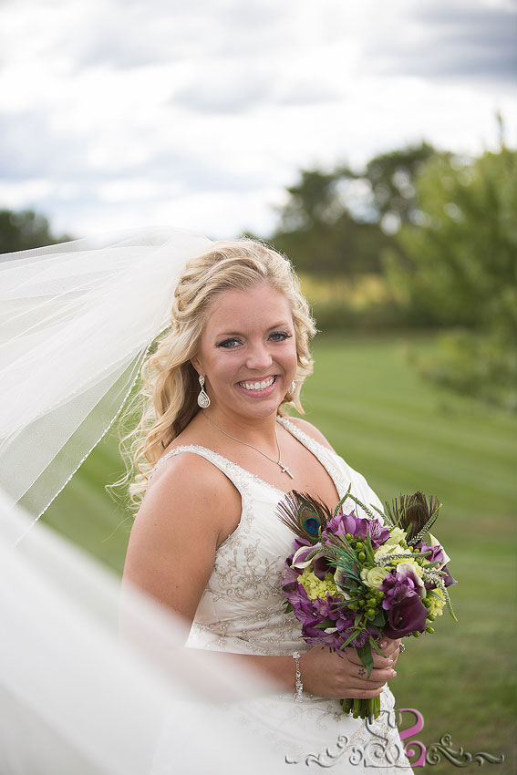 12-bride-in-grassy-field-with-wind-in-veil-lawrence-wedding-photographer