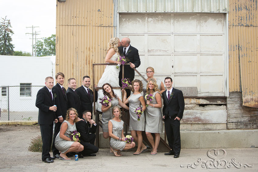 33-wedding-party-smiling-in-front-of-rugged-garage-grand-rapids-wedding-photographer
