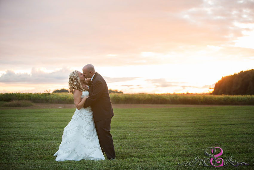 42-bride-and-groom-kiss-in-grassy-field-with-sunset-lawrence-wedding-photographer