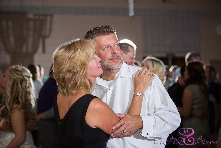 52-father-and-mother-of-bride-embrace-during-reception-kansas-city-wedding-photographer