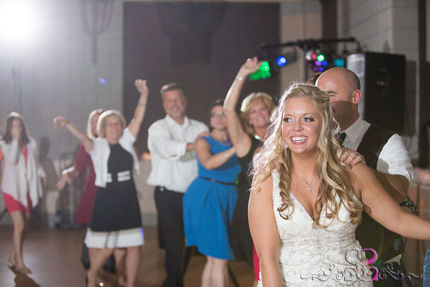 53-smiling-bride-leads-train-around-reception-grand-rapids-wedding-photographer