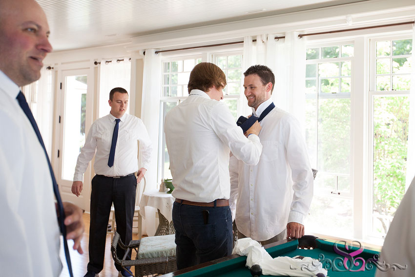 05-groomsmen putting tie on groom michigan wedding photographer