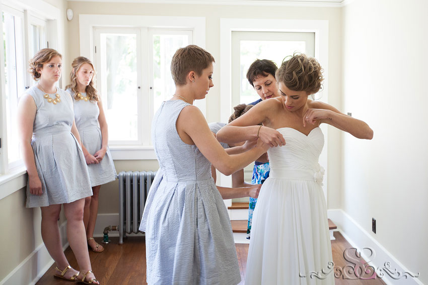 08-bridesmaid and mom helping bride put dress on holland michigan photographer