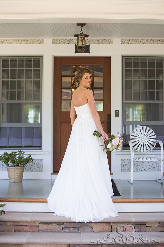 13-back of bride standing on front porch with bouquet michigan wedding photographer