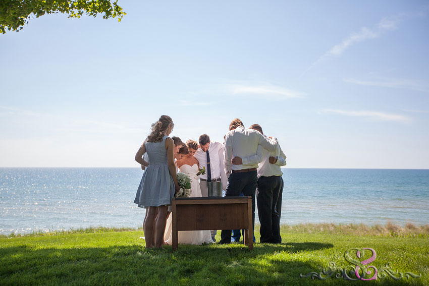 35-wedding party prays during ceremony holland michigan photographer