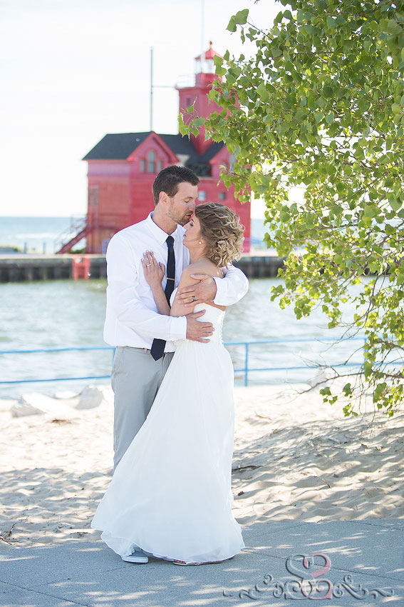 45-bride and groom hug on beach with lighthouse destination wedding photographer