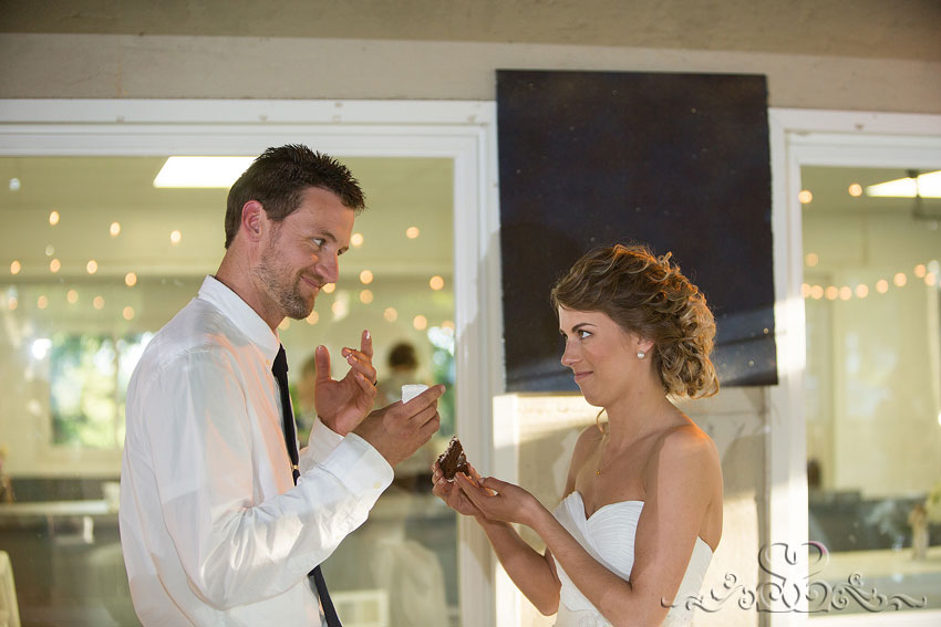57-bride and groom hesitate before feeding each other cake grand rapids michigan photographer