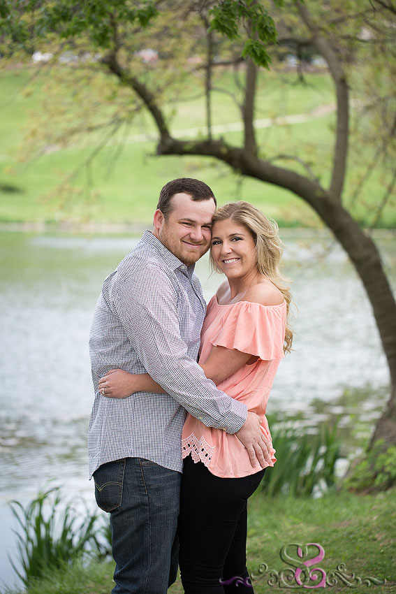 02-man and woman hug and smile in front of lake kansas university photographer