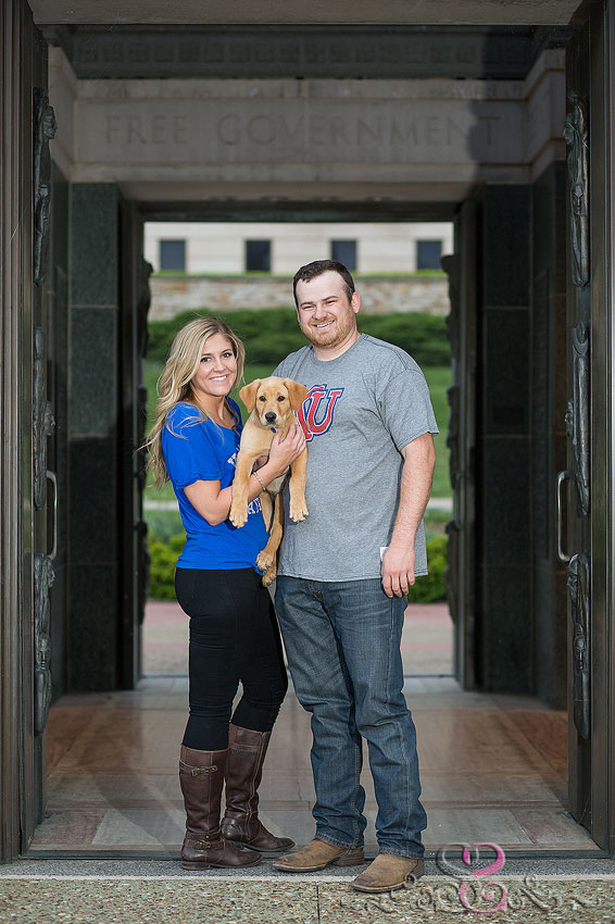 17-engaged couple smile with puppy under campanile grand rapids wedding photographer