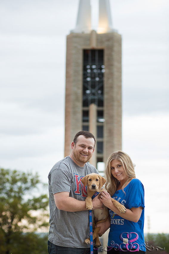 20-engaged couple smile with puppy in front of campanile grand rapids wedding photographer