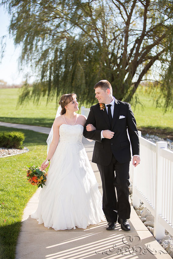 38-bride-and-groom-walk-along-fence-michigan-photographer