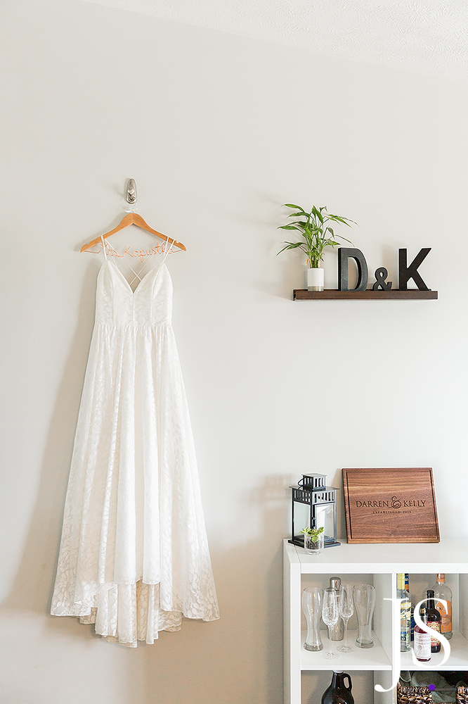 White wedding dress hangs on wall
